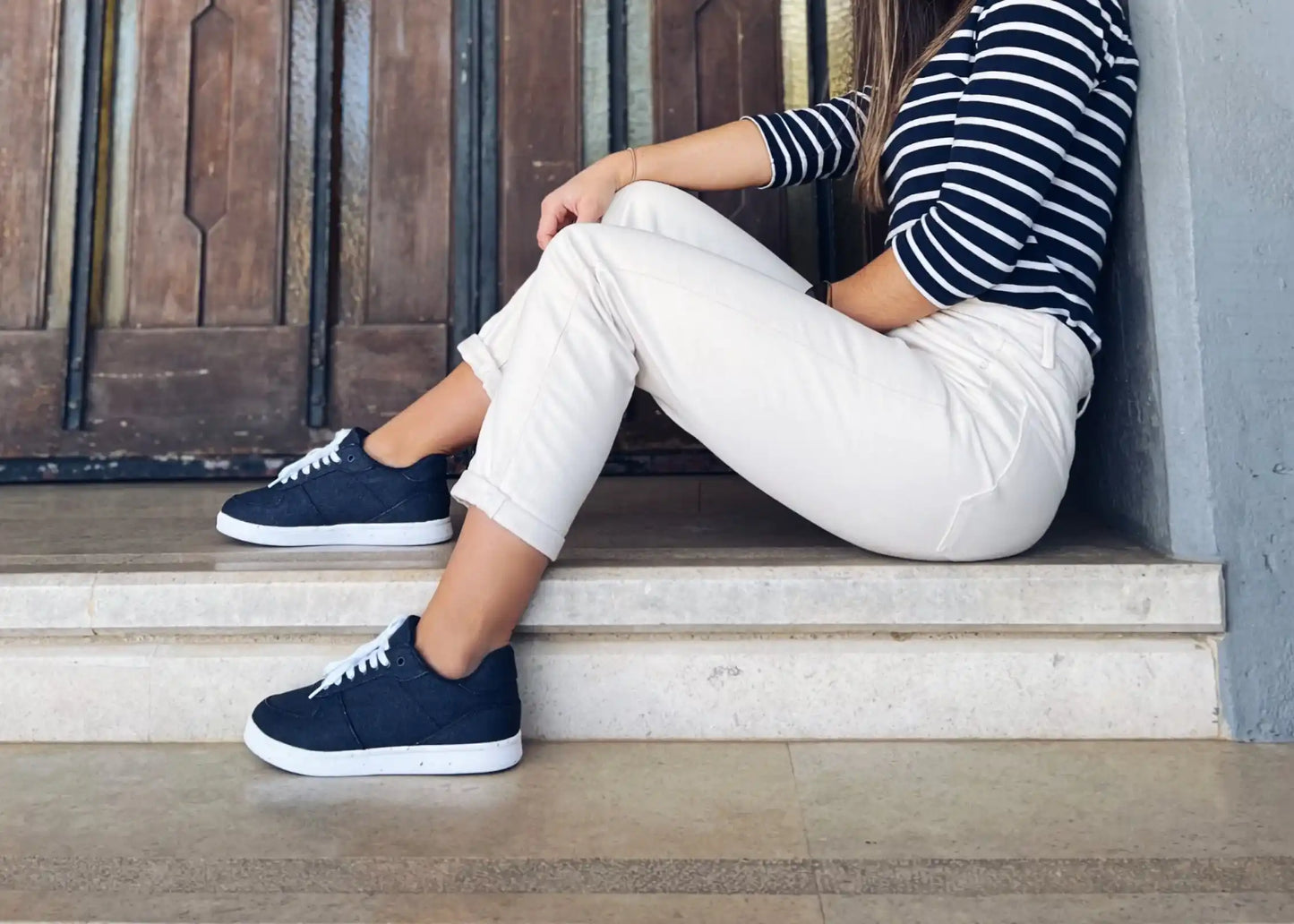 A woman in navy blue Seeker for Women hemp shoes by 8000 Kicks.